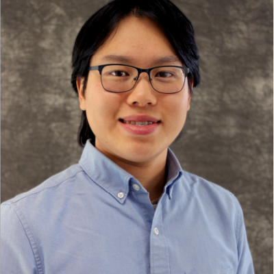 Jonathan Eng smiles. He has black hair and glasses, and he wears a blue button up.