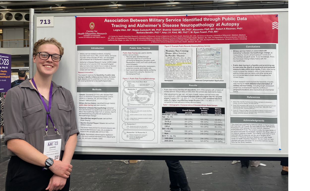 Leigha Vilen stands next to her poster at AAIC. The poster is large with a red label and detailed graphs and text.