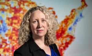 Dr. Amy Kind Director of the UW Center for Health Disparities Research is pictured at the University of Wisconsin–Madison on Jan. 21, 2026 in front of a map depicting the national Area Deprivation Index (ADI), a scientifically validated measure of the adverse social exposome (i.e., neighborhood disadvantage) that can be used to evaluate and improve factors that impact health across populations. (Photo by Taylor Wolfram / UW–Madison)